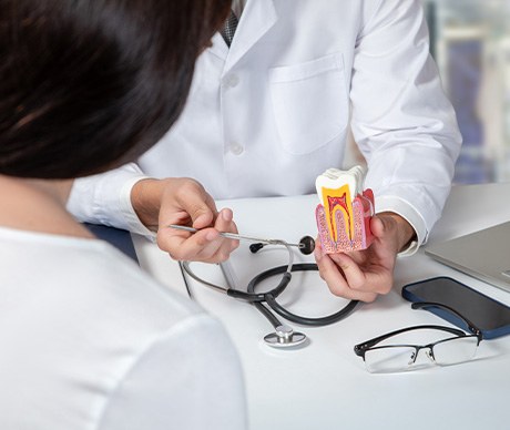 Dentist showing patient a model tooth