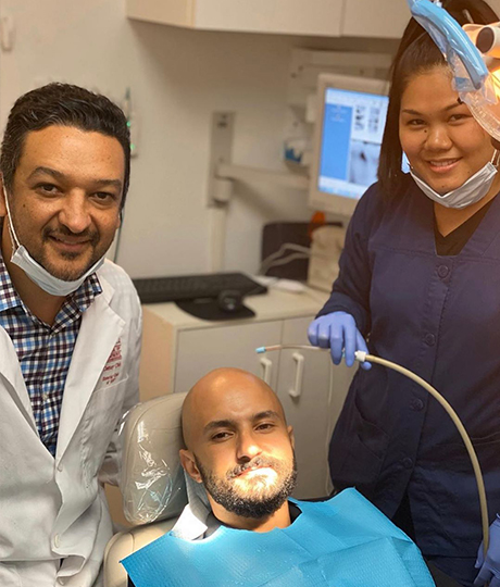 Dr. Saad and team member with dental patient