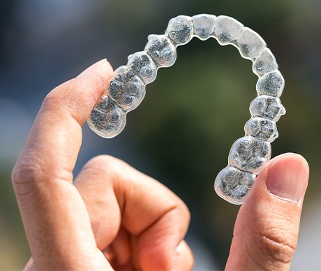 Hand holding clear aligner