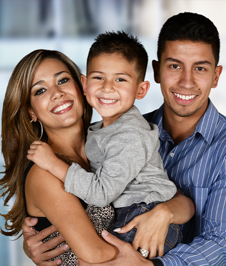 Family of three smiling bright