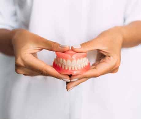 Lady presents viewer with dentures