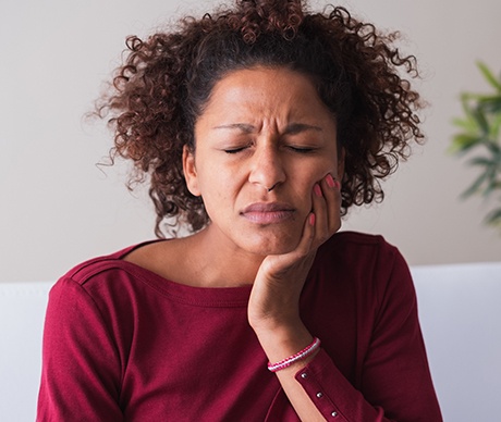 Woman holding cheek in pain