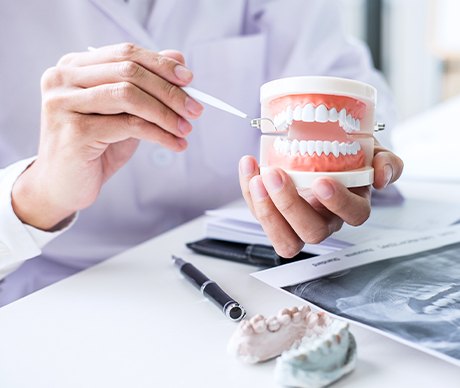 Dentist pointing to model teeth