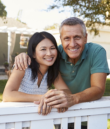 Older man and woman smiling outdoors