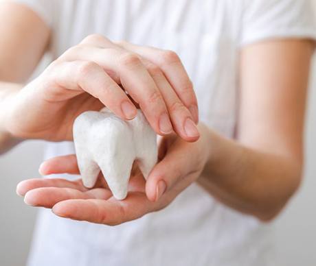 a person holding and covering a tooth