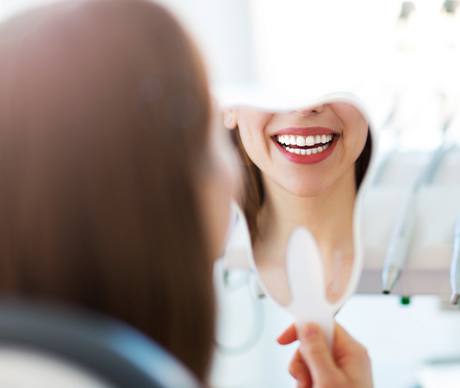 Woman looking at smile in mirror