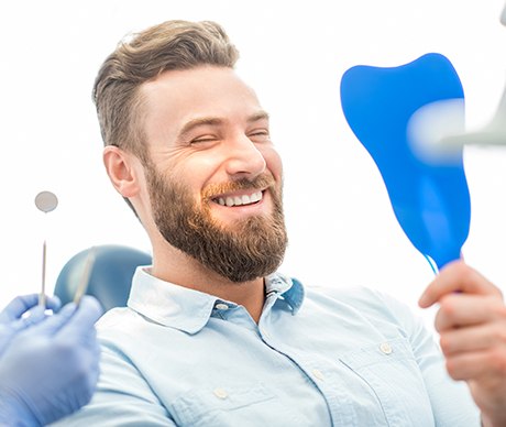 Man looking at smile in mirror