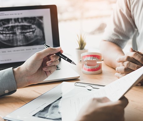 Dentist and patient reviewing dental insurance forms