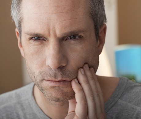 Man in pain holding jaw