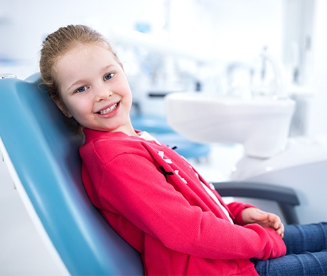 Smiling young girl in dental chair