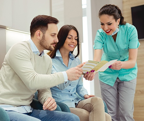 Man and woman talking to dental team member