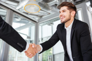 Man with nice smile shaking hands after interview