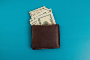 Brown wallet with paper money showing