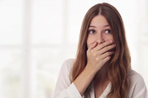 woman covering her mouth because she doesn’t have good oral health