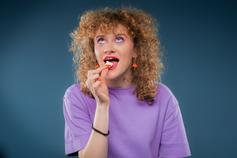 a woman putting chewing gum in her mouth