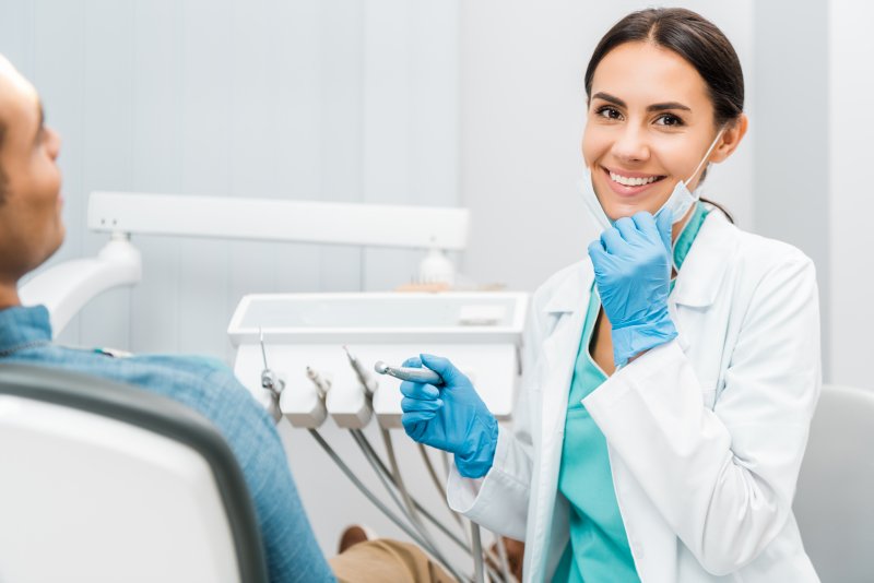 a dentist pulling their mask down to smile