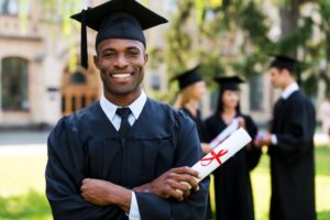 a man smiling with beautiful teeth from cosmetic treatments on graduation day